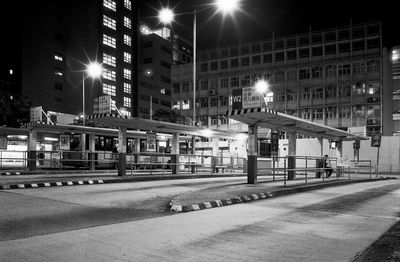 Illuminated street lights by buildings in city at night