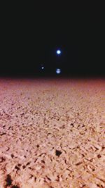 Scenic view of illuminated land against sky at night