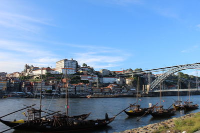 Boats moored at harbor against sky