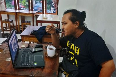 Side view of man holding coffee cup