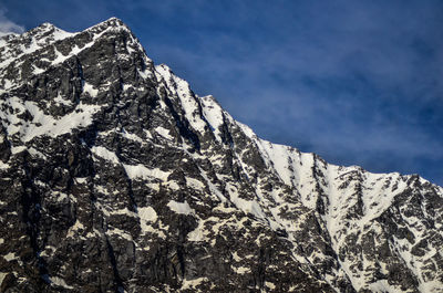 Low angle view of snowcapped mountain against sky