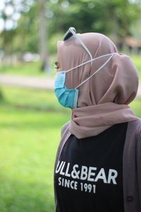 Rear view of woman standing on field