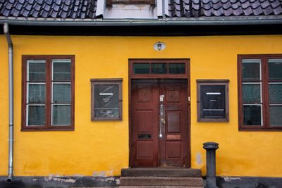 Red door of old yellow building