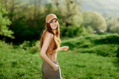 Portrait of young woman standing on field