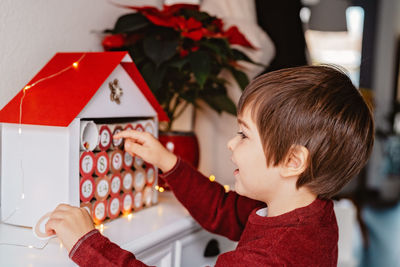 Portrait of boy holding christmas decoration at home