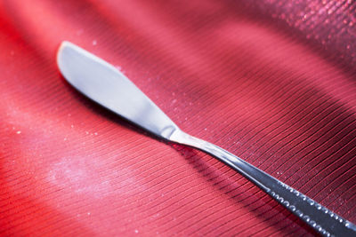 High angle view of table knife on red tablecloth