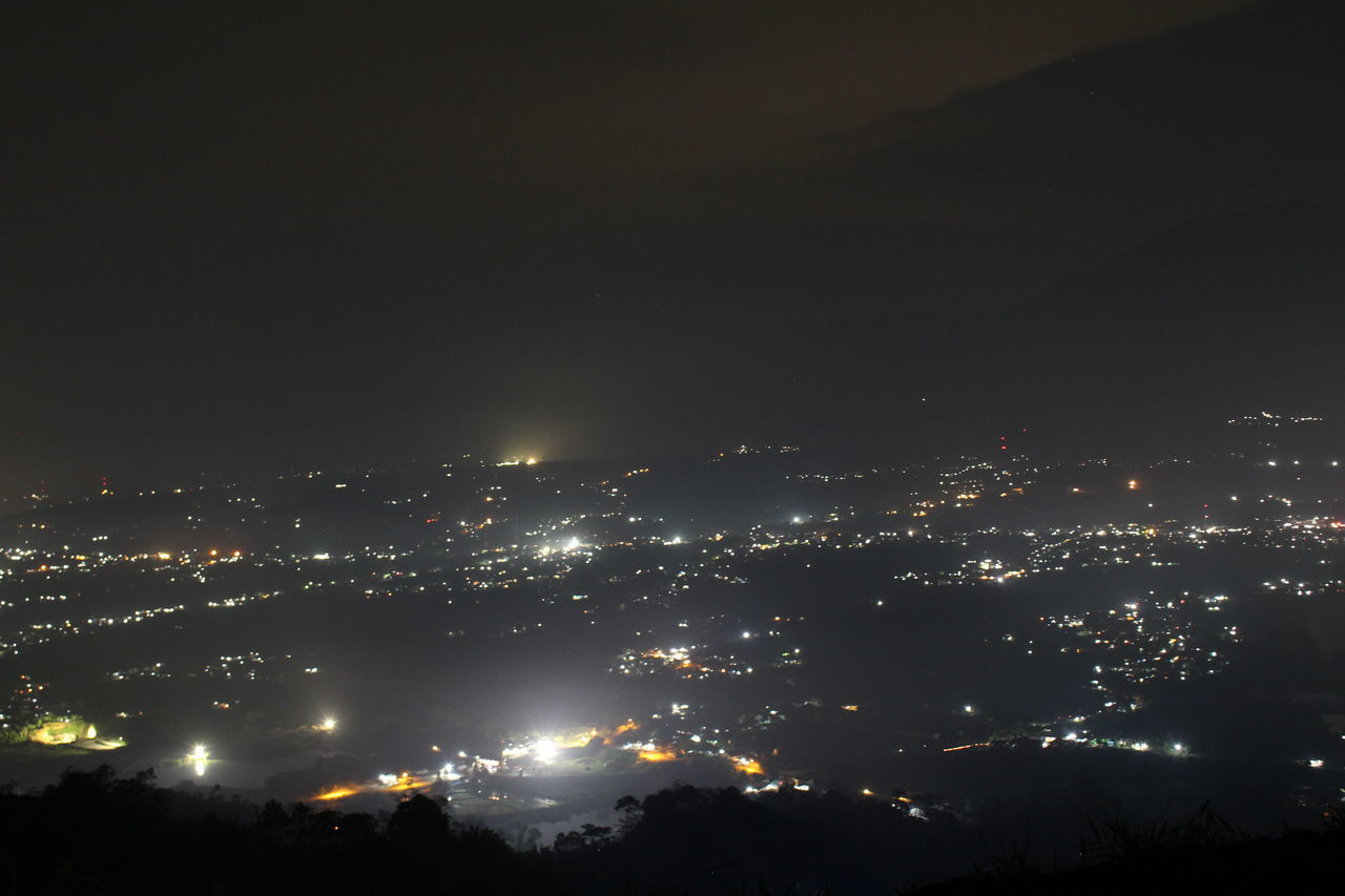 HIGH ANGLE VIEW OF ILLUMINATED BUILDINGS IN CITY AGAINST SKY