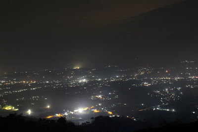 High angle view of illuminated buildings against sky at night