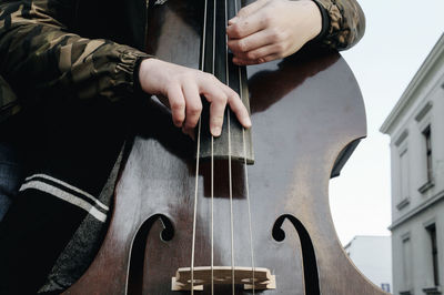 Midsection of man playing cello