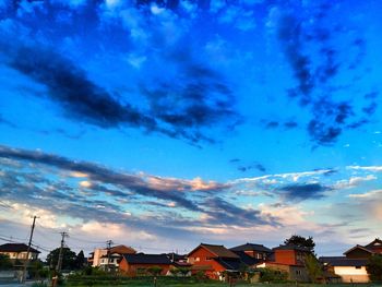 Houses in town against cloudy sky