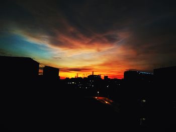 Silhouette cityscape against sky during sunset