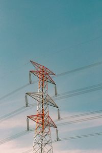 Low angle view of electricity pylon against clear sky