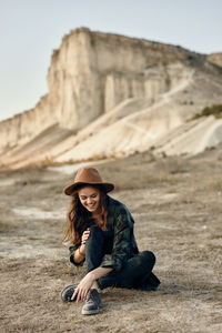 Portrait of woman sitting on rock