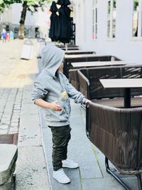 Side view of boy standing on footpath