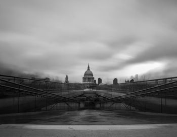 Bridge over river against cloudy sky