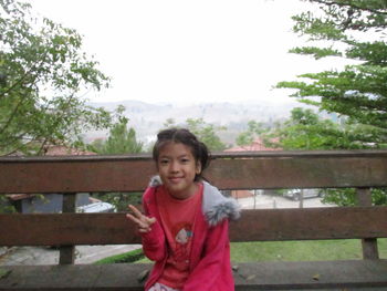 Portrait of smiling girl standing against sky