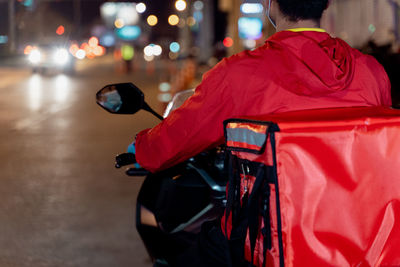 Rear view of person holding illuminated street at night