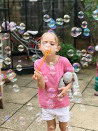 Full length of girl blowing bubbles