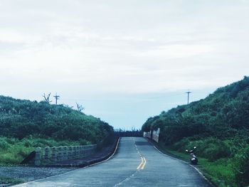 Road amidst trees against sky