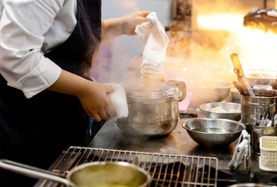 Midsection of man preparing food in kitchen