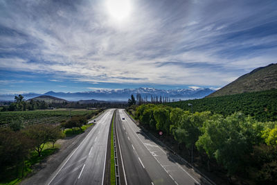 Road leading towards mountain against sky