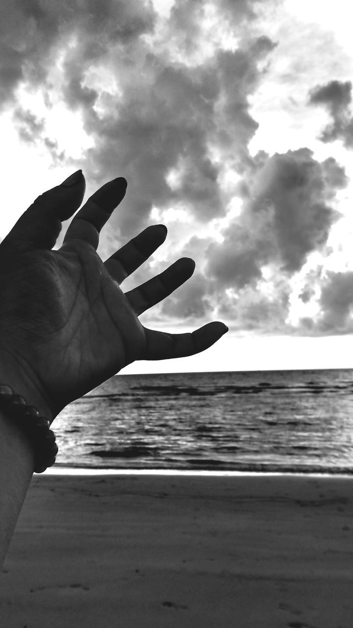 person, sky, part of, holding, cropped, water, unrecognizable person, sea, beach, personal perspective, human finger, lifestyles, leisure activity, horizon over water, men, nature, cloud - sky