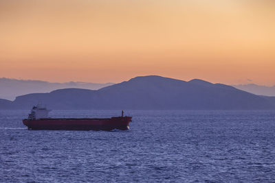 Scenic view of sea against sky during sunset with big ship sailing, greece 
