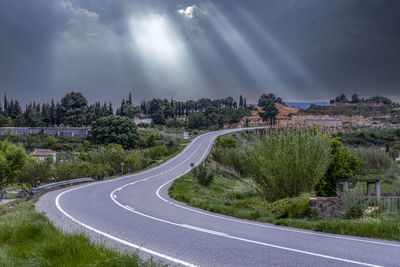 Road amidst trees against sky