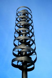 Low angle view of communications tower against clear blue sky