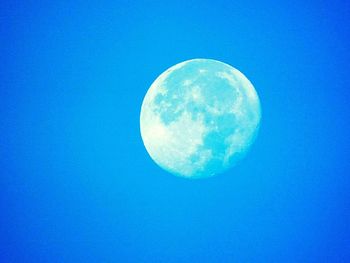 Low angle view of moon against blue sky