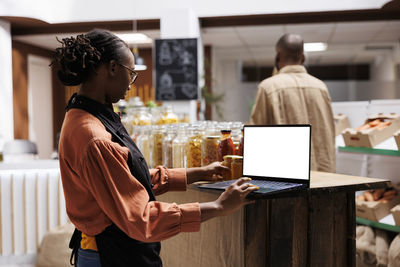 Side view of man using digital tablet while sitting in office