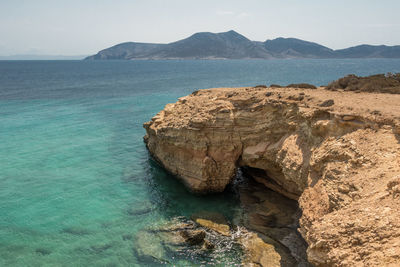 Rock formations in sea against sky