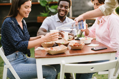 Midsection of friends having food at restaurant