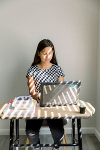 Young teen girl doing homework in a wooden desk