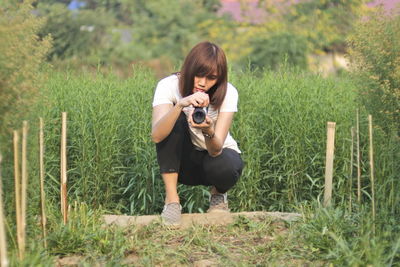 Full length of senior woman holding camera