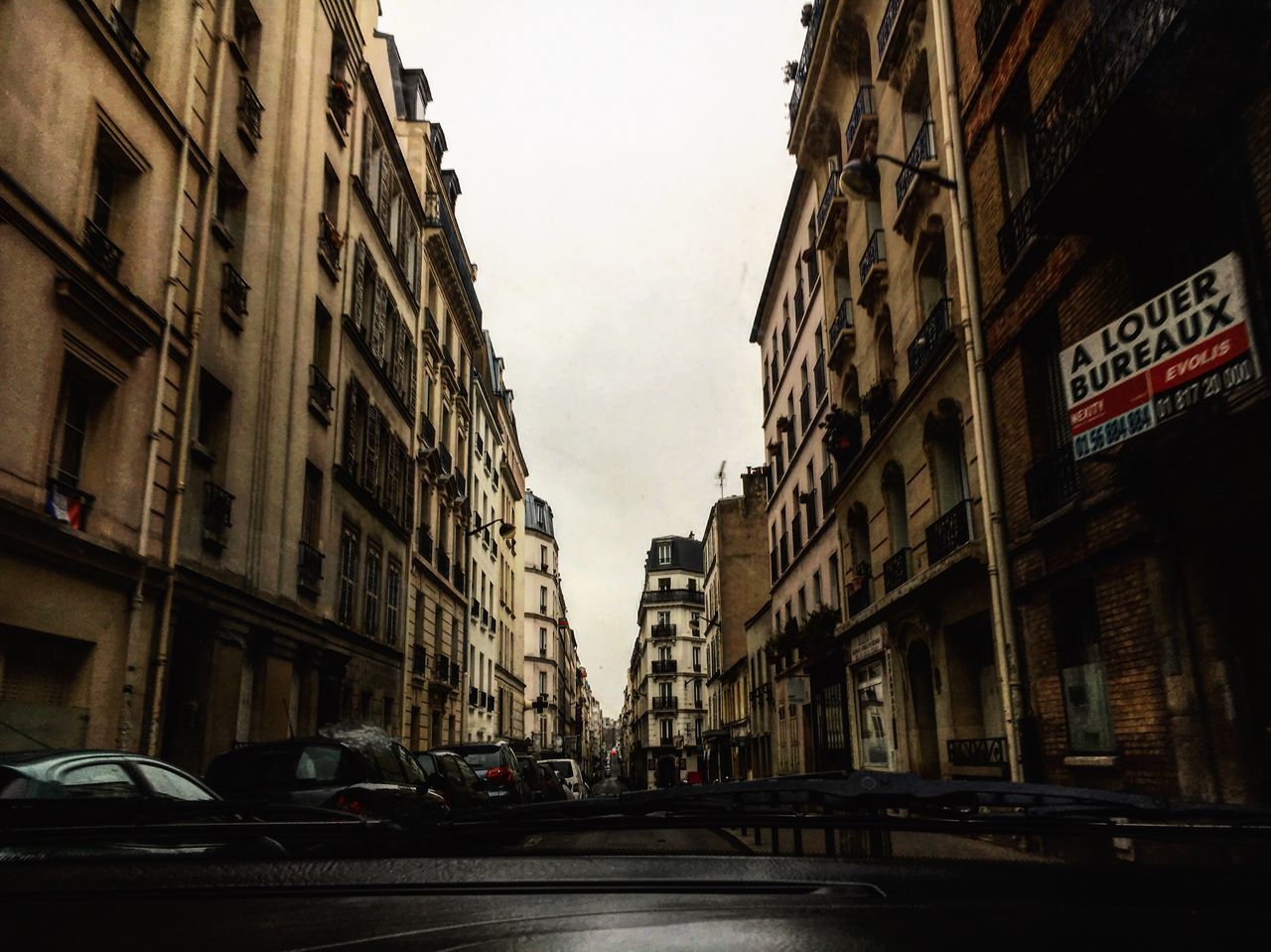 CARS ON ROAD AGAINST BUILDINGS