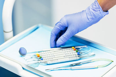 Cropped hand of dentist holding dental equipment at clinic
