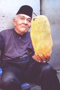 Portrait of man wearing hat sitting outdoors