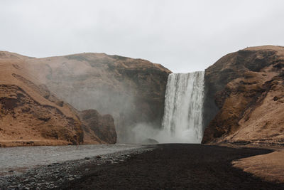 Scenic view of waterfall against sky