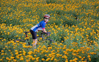 Full length of man and yellow flowers on field