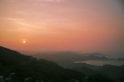 Scenic view of silhouette mountains against romantic sky at sunset