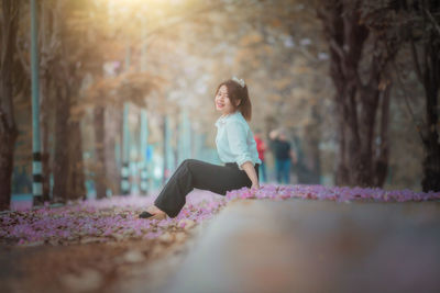 Full length of woman sitting on land