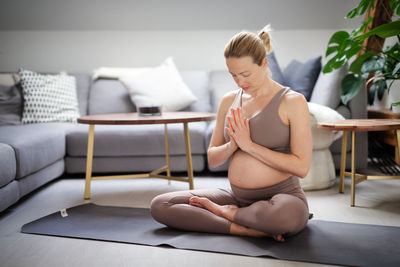 Side view of woman exercising at home