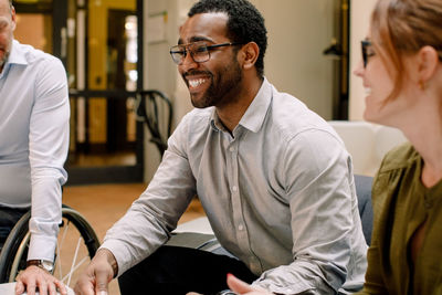 Smiling business colleagues sitting in office during sales meeting