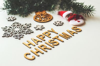 Close-up of text and christmas decorations over white background