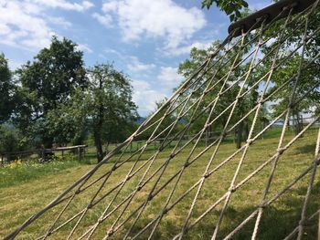 Trees on field against cloudy sky