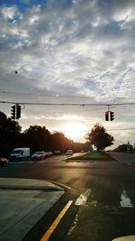 Cars on road against sky during sunset