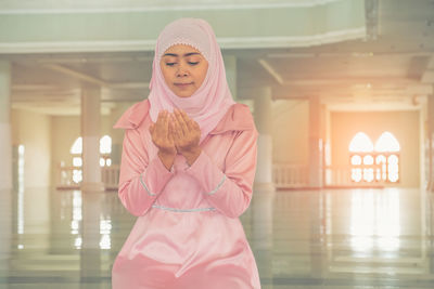 Midsection of woman standing against illuminated light