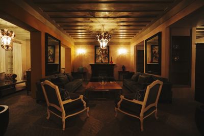 Empty chairs and tables in illuminated building