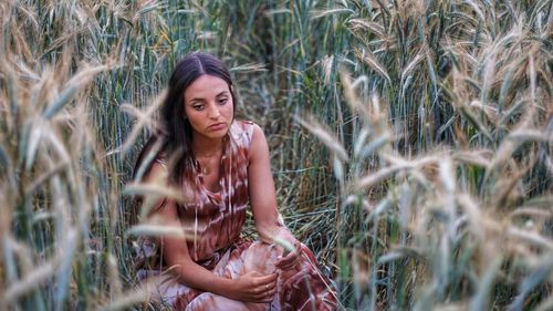 Portrait of beautiful young woman on field